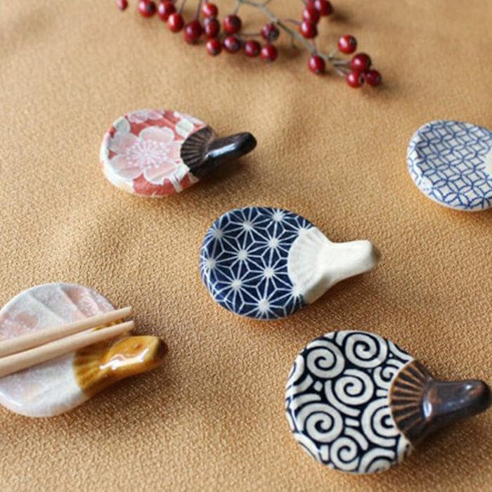 Set of colorful fan-themed ceramic chopstick rests on a dining table