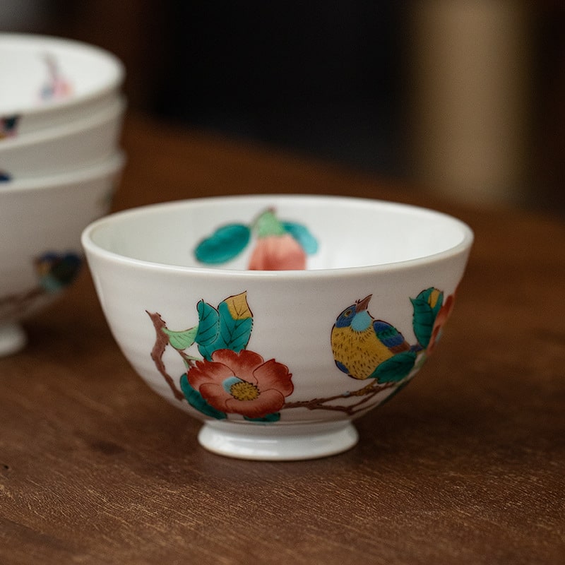 Hand-painted cherry blossom and bird rice bowl on wooden table