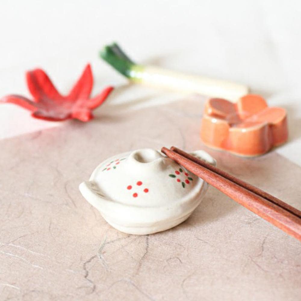 Set of colorful fan-themed ceramic chopstick rests on a dining table