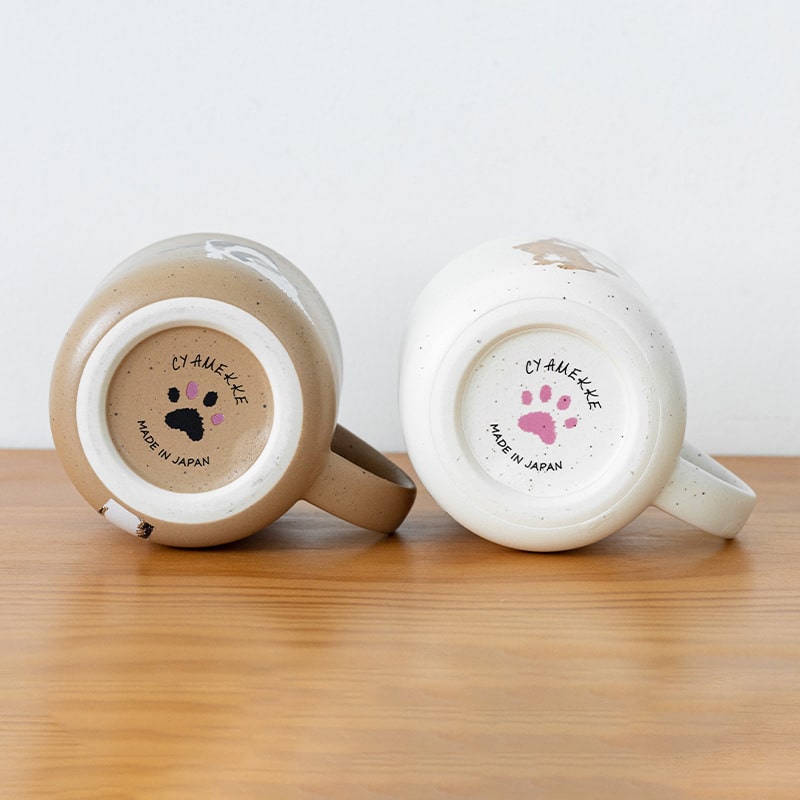 Interior detail of speckled white ceramic cat-themed mug.