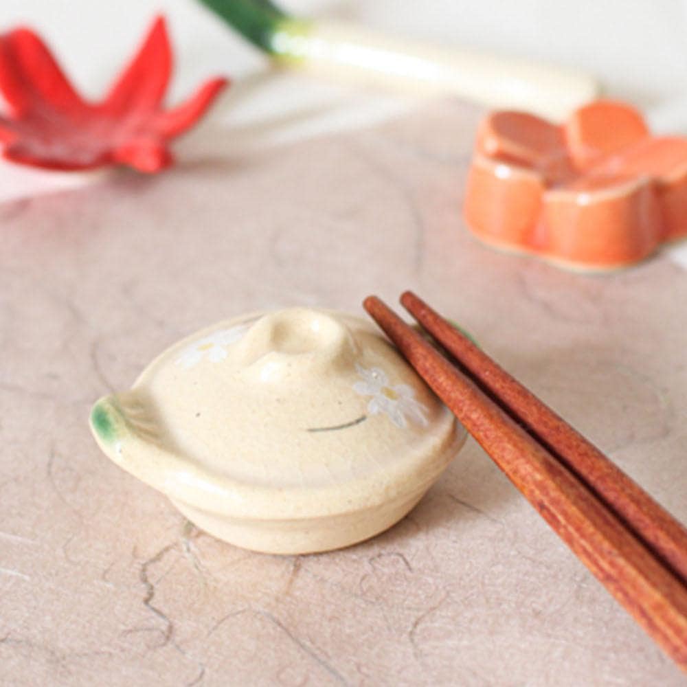 Close-up of a ceramic fan-style chopstick holder with intricate patterns