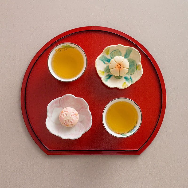 Elegant small Japanese floral dessert and dipping plates on a red tray