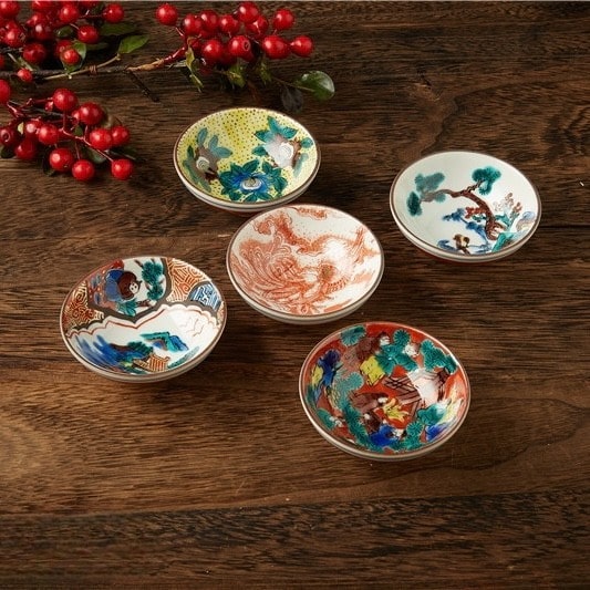 Close-up of ceramic tea cups featuring traditional Japanese art.