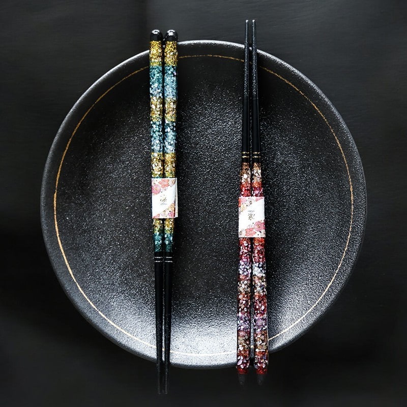 Luxurious black chopsticks with gold and red detailing.