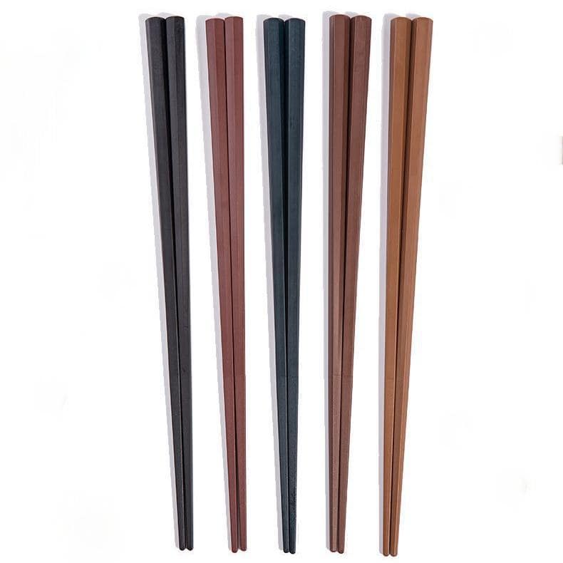Pair of solid wood chopsticks resting on a ceramic holder