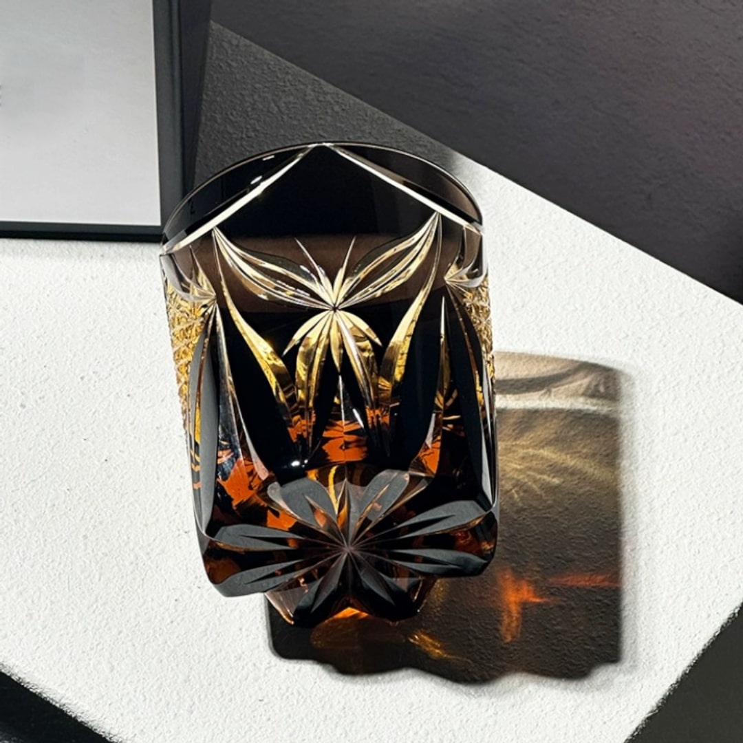 Close-up of Japanese crystal whiskey glass in luxurious golden tone, featuring intricate Edo Kiriko design.