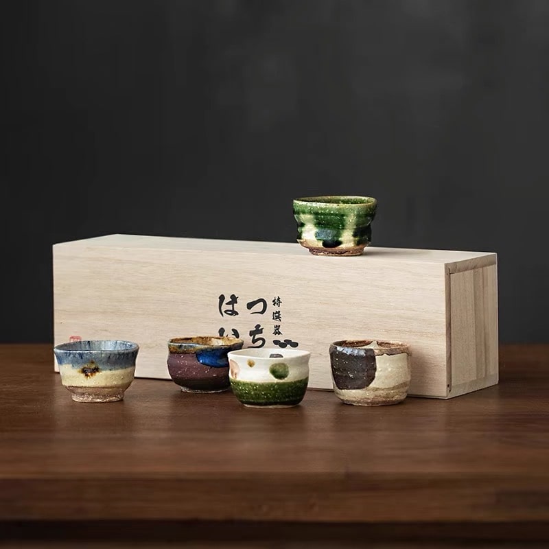 Handmade ceramic sake cups with rustic textures and earthy tones.