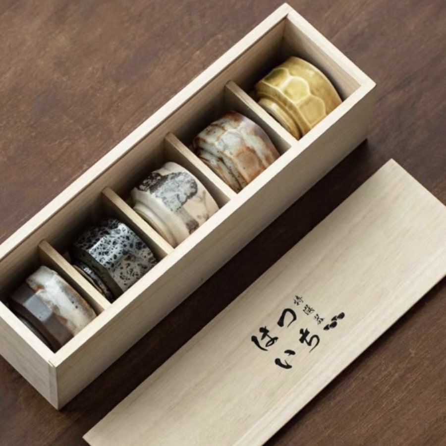 Set of handcrafted ceramic tea cups with textured finishes and earthy tones.