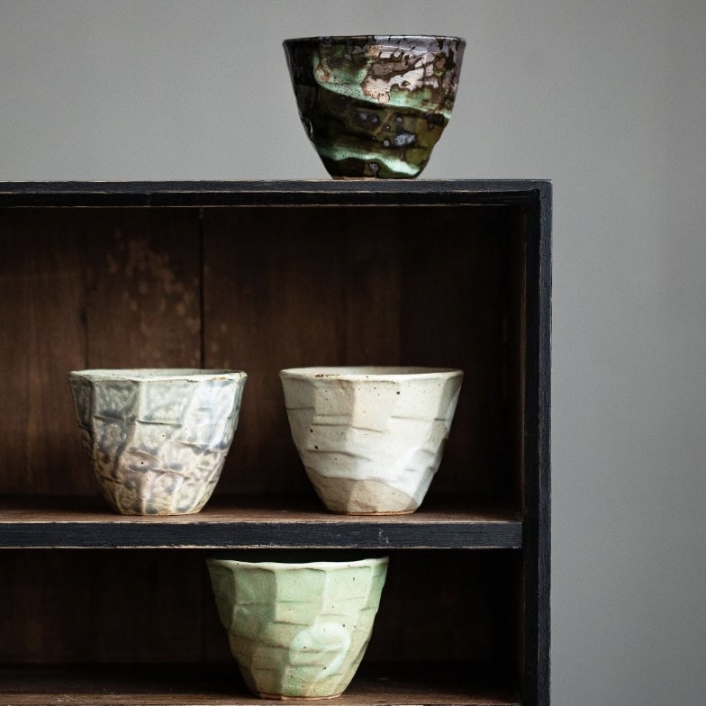 Elegant tea cups with organic textures and earthy tones.