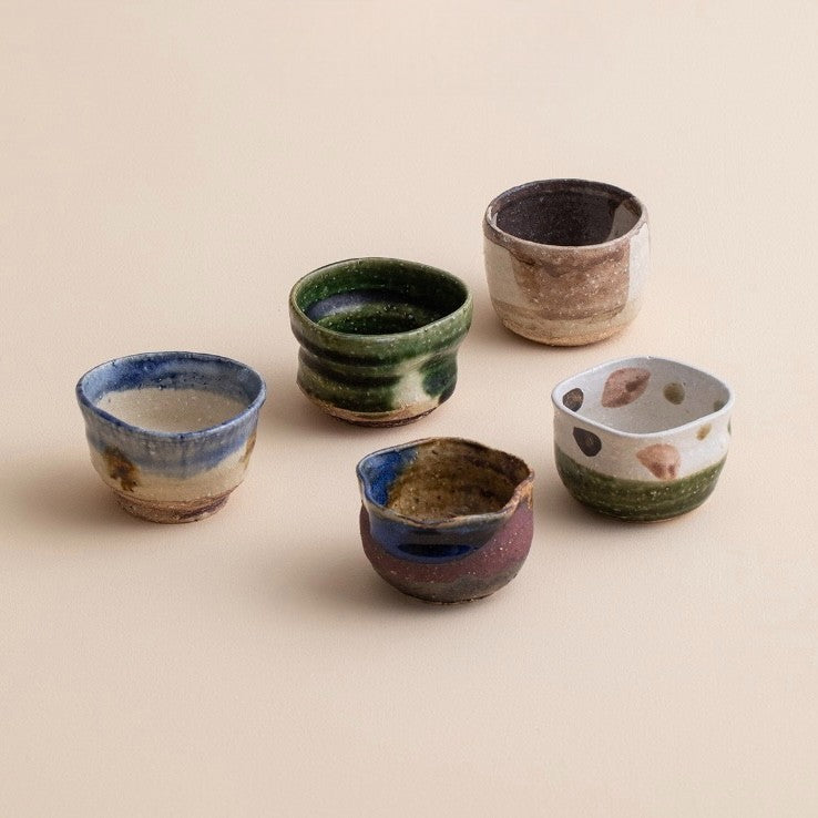 Rustic handcrafted ceramic tea cups in earthy tones.