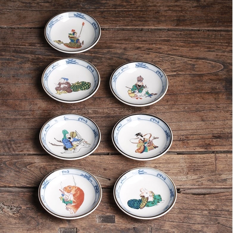 Close-up of vibrant hand-painted designs on Japanese porcelain tea cups.