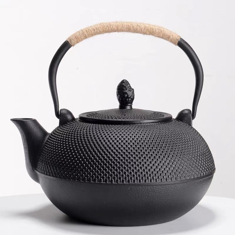 Side view of textured black cast iron tea pot with drip-free spout.