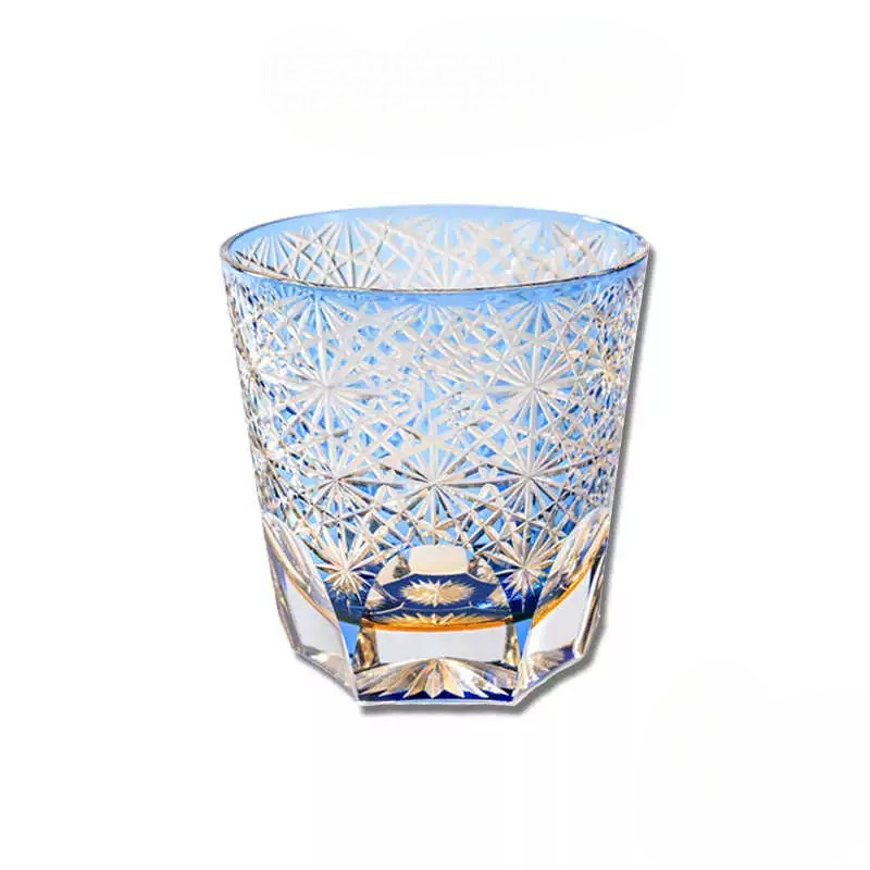 Close-up of intricate chrysanthemum pattern on a blue Edo Kiriko crystal whiskey glass.