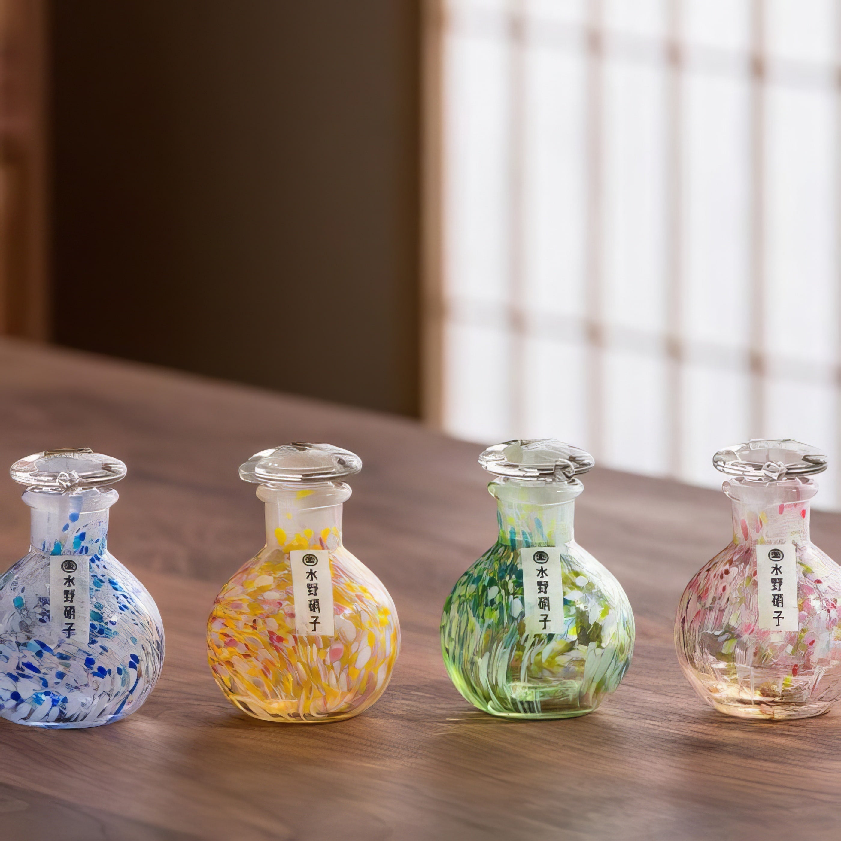 Set of colorful Mizuno Glass bottles on wooden dining table.