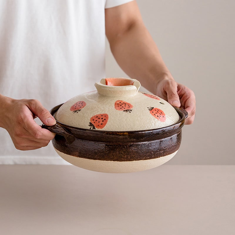 Handcrafted ceramic pot with strawberry design lid.