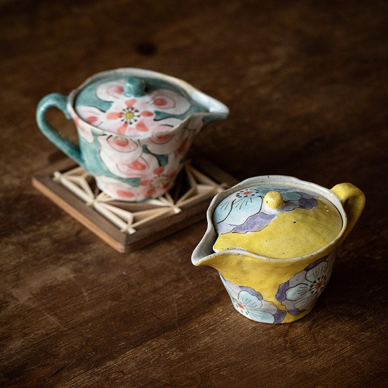 Hand-painted floral ceramic teapot on wooden table