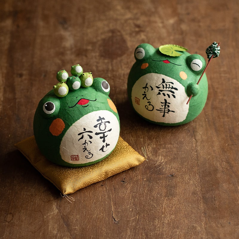 Handcrafted Japanese Longhutang Peace Frog ceramic ornament on a golden cushion.