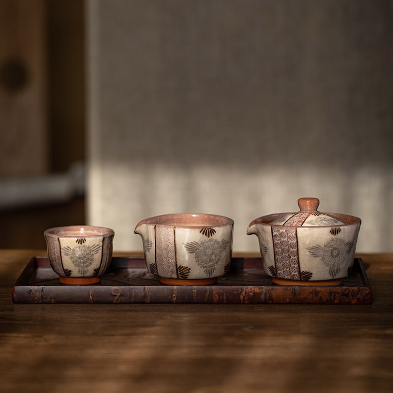 Handcrafted Japanese Kiyomizu-yaki teapot and cup on a wooden tray.