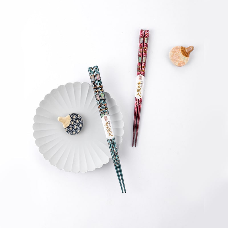 Japanese Wakasa wooden chopsticks with vibrant lacquer finish on a white plate.