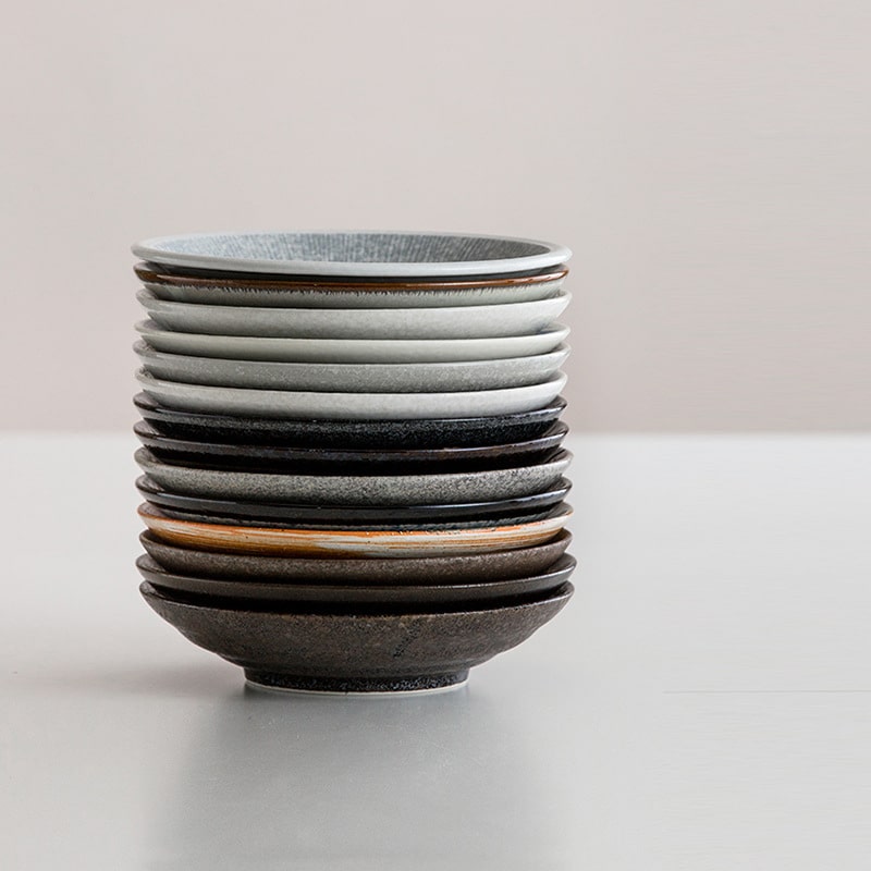 Stack of handcrafted ceramic plates in earthy tones