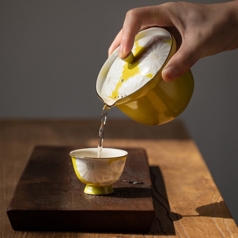 Nishikawa Sadazaburo Kiyomizu-yaki teapot pouring tea into a matching teacup.