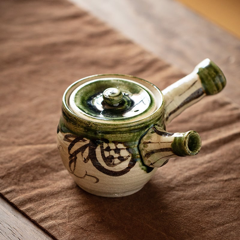 Side view of authentic Japanese Oribe Kyusu teapot with a green glaze.