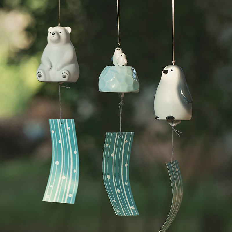 Ceramic bear wind chime with soft blue accents.