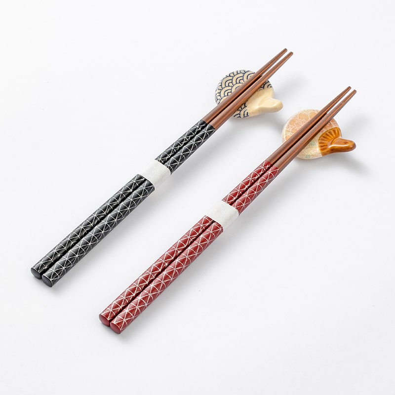 Red and black Japanese wooden star point chopsticks with geometric patterns.