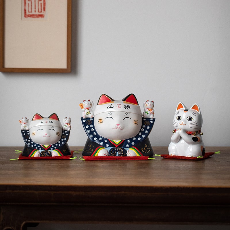 Japanese lucky cat ceramic decorations on a wooden table.