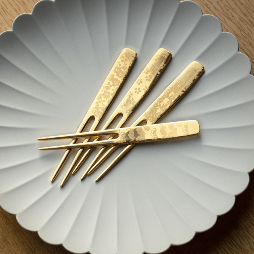 Close-up of the floral-etched gold dessert fork