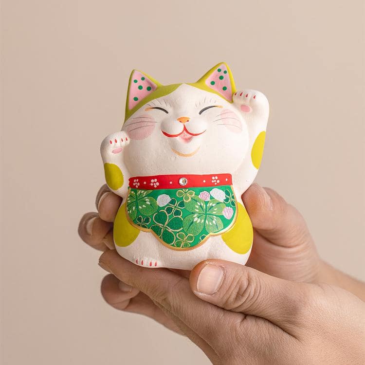 Lucky cat figurine with colorful apron on decorative mat