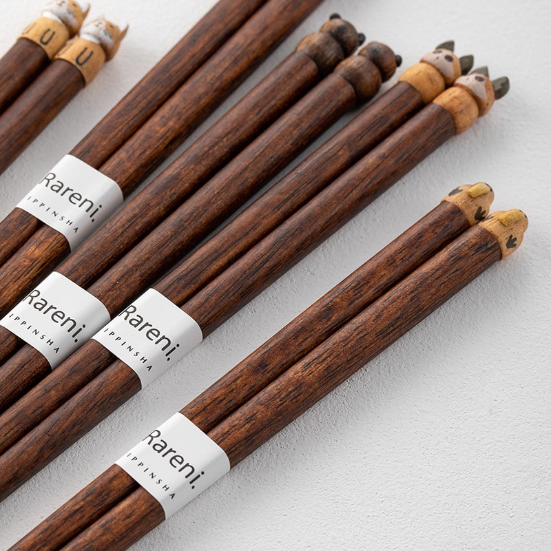 Set of animal-themed wooden chopsticks on red serving tray