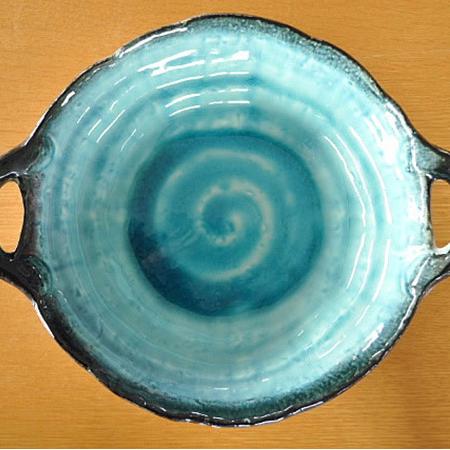 Vibrant turquoise ceramic long plate with fried appetizers.