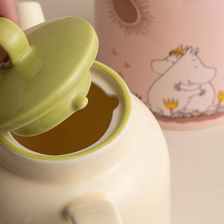 Moomin tea set with green-lidded teapot and matching cups.