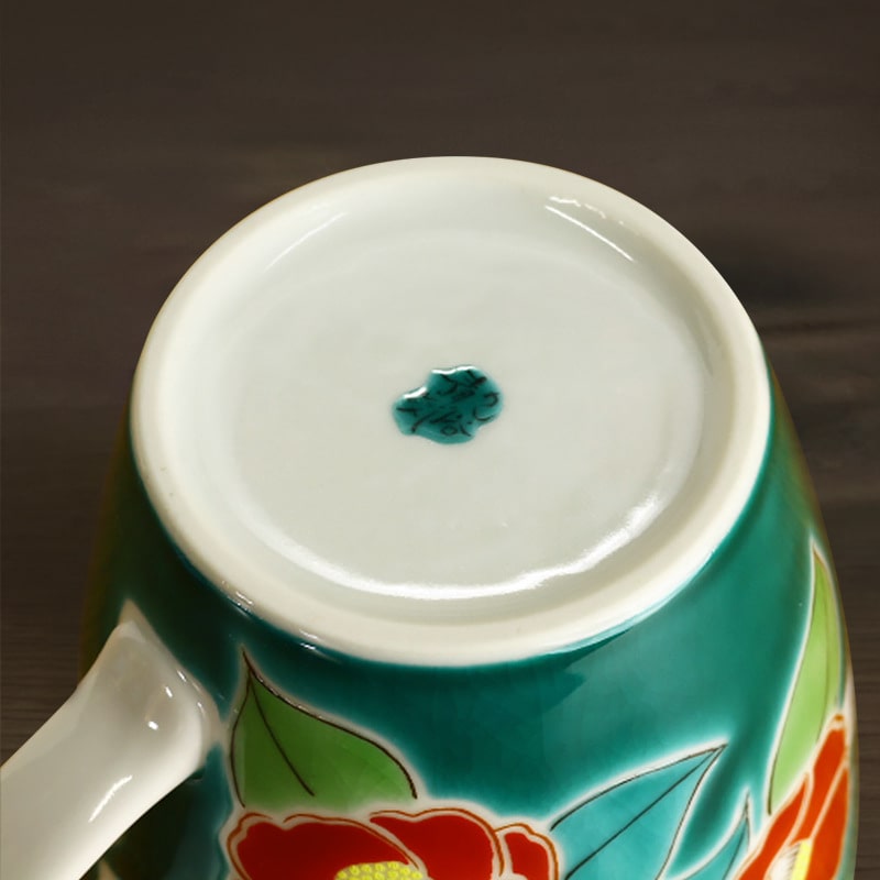 Bottom view of a floral ceramic mug with green and red accents