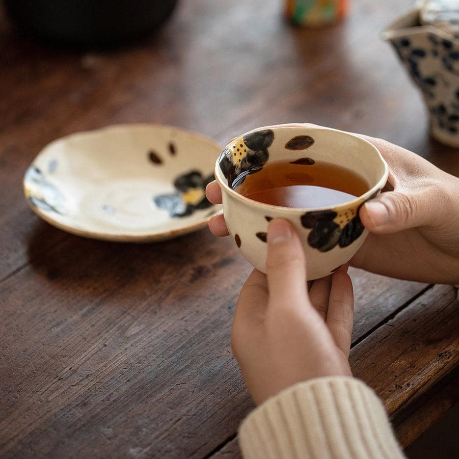 Artistic cup and saucer featuring a vibrant cherry blossom motif