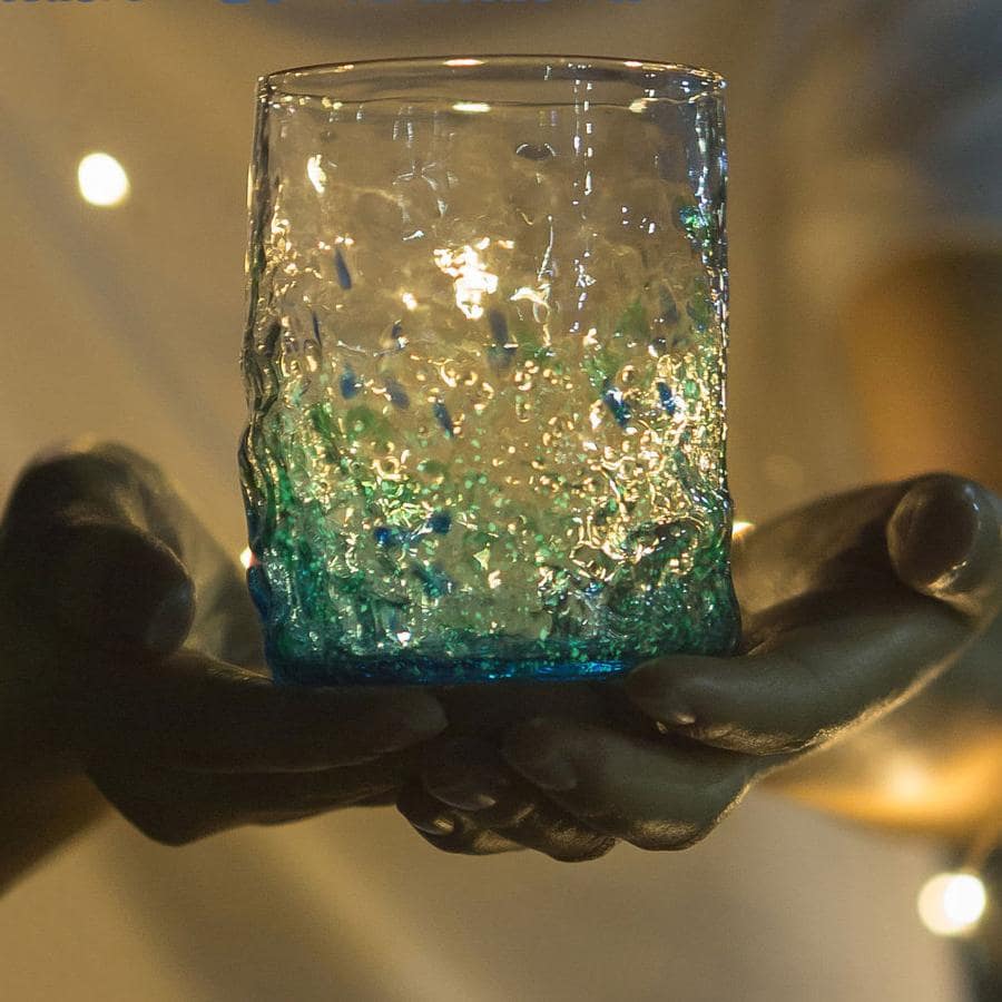 Two luminous glasses filled with iced beverages and lemon