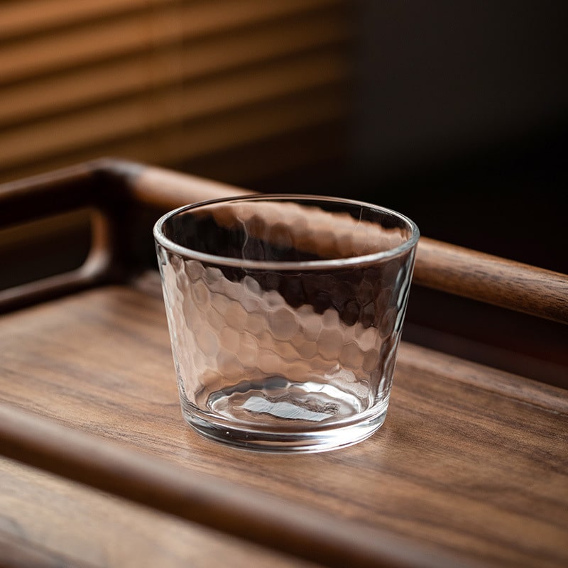 Close-up of a textured glass cup with amber tint.