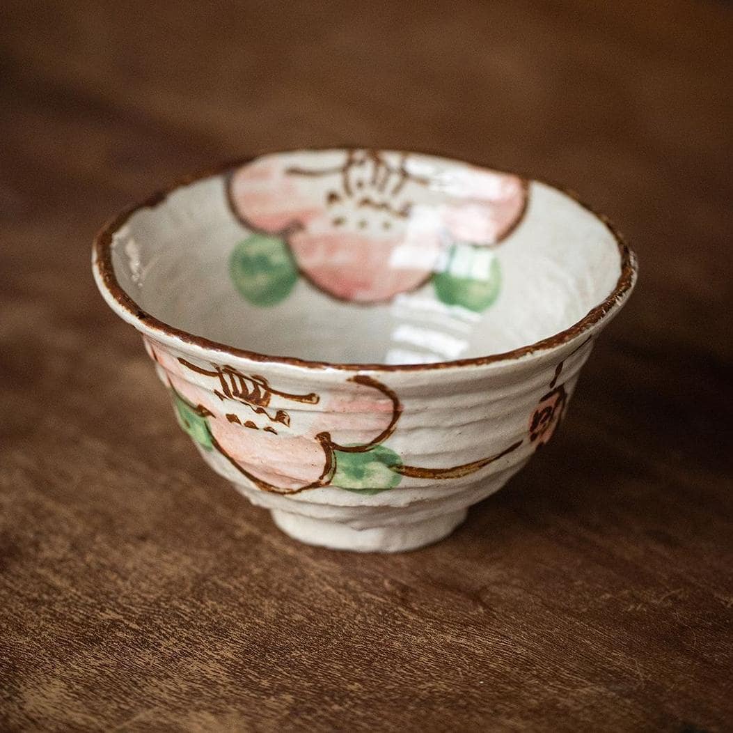 Close-up of floral details on artisanal ceramic tableware set.