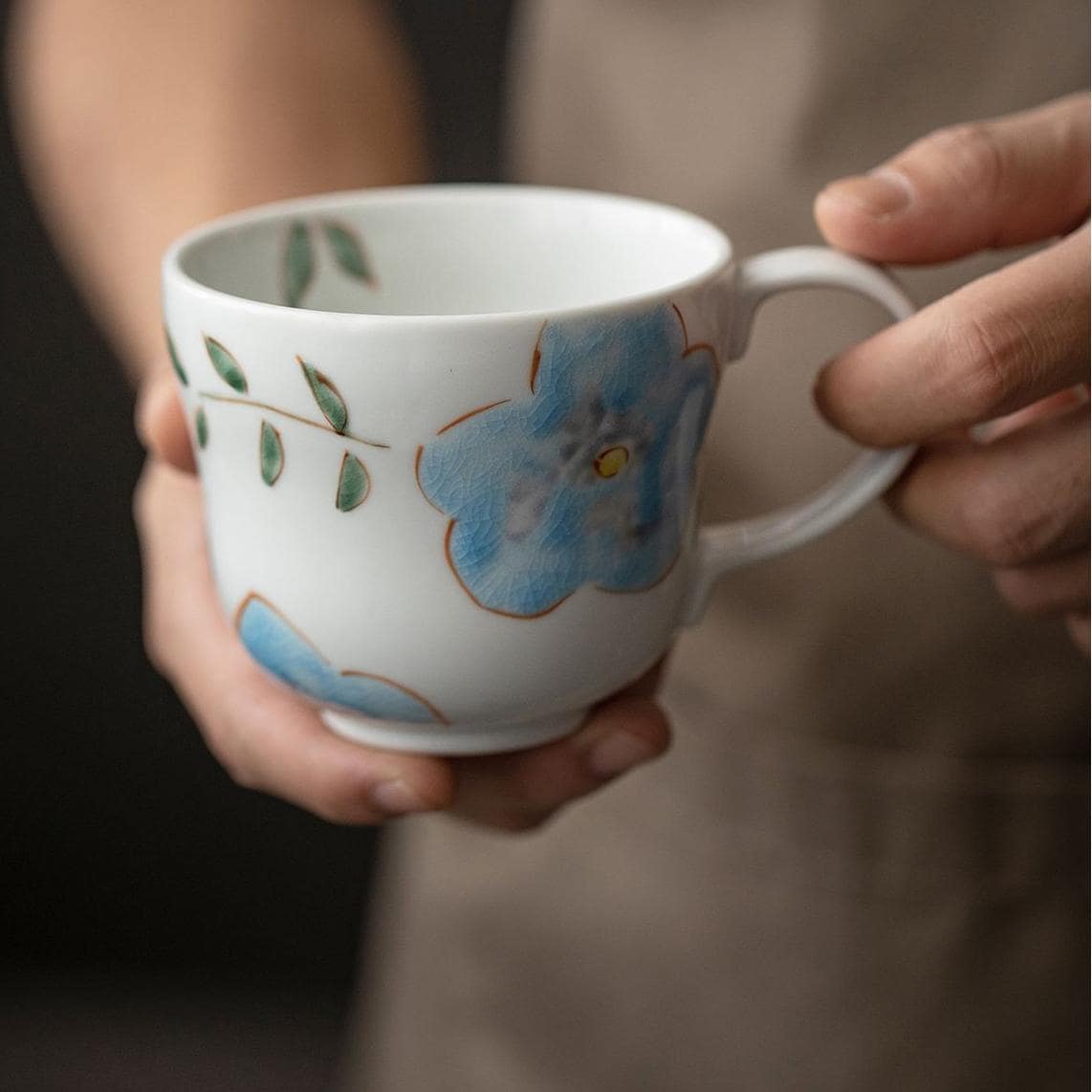 Mug with red floral patterns and tea displayed on a wooden table