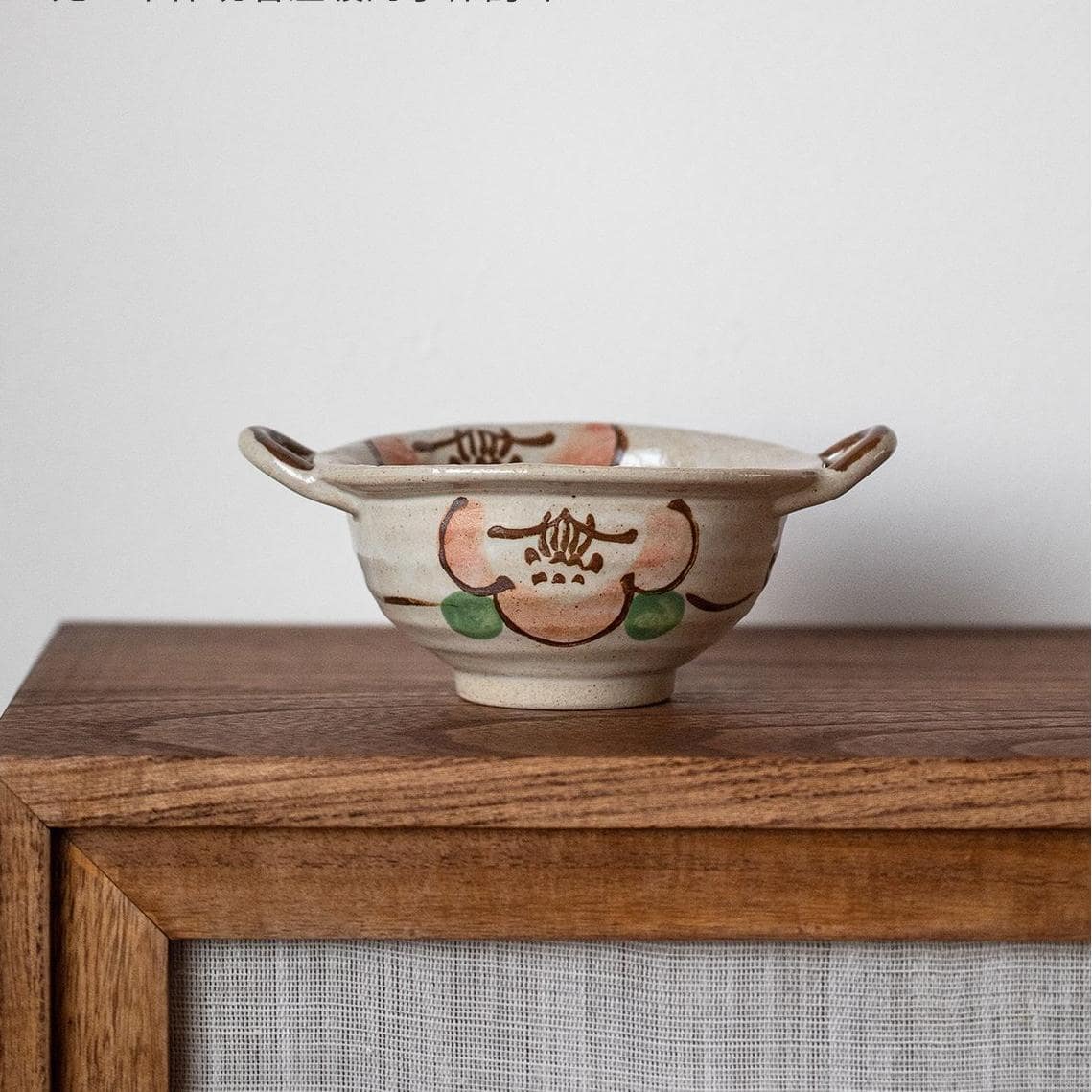 Rustic handcrafted serving bowl with earthy tones and side handles.