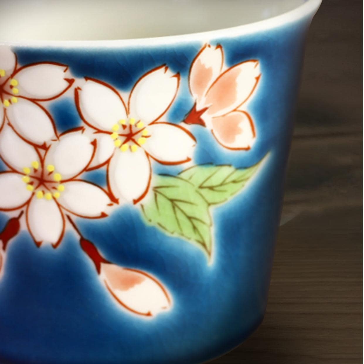 Bottom view of a floral ceramic mug with green and red accents