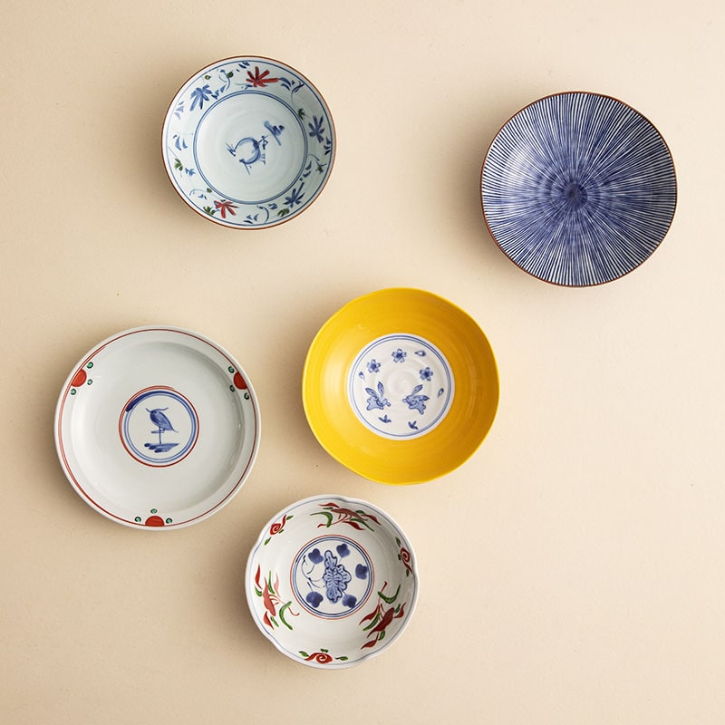 Hand-painted Japanese ceramic plates set displayed on a wooden table