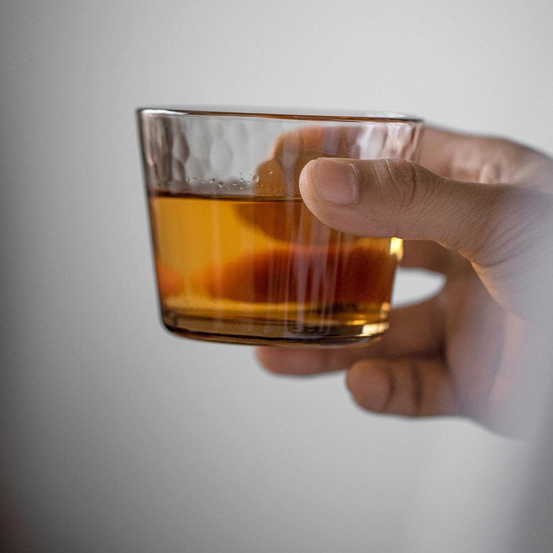 Close-up of a textured glass cup with amber tint.