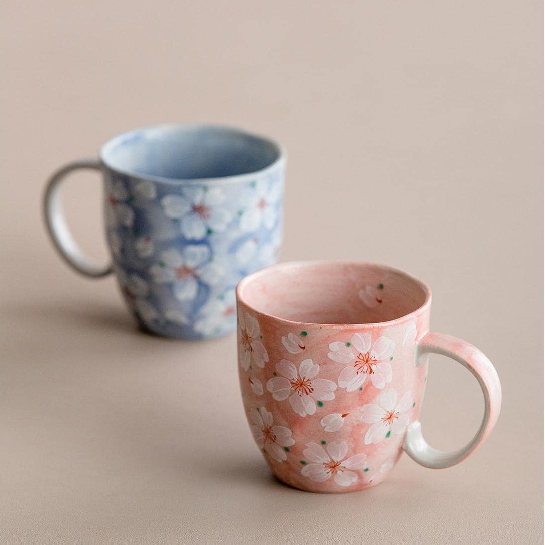 Artistic pink cherry blossom coffee cup, perfect for gifting.