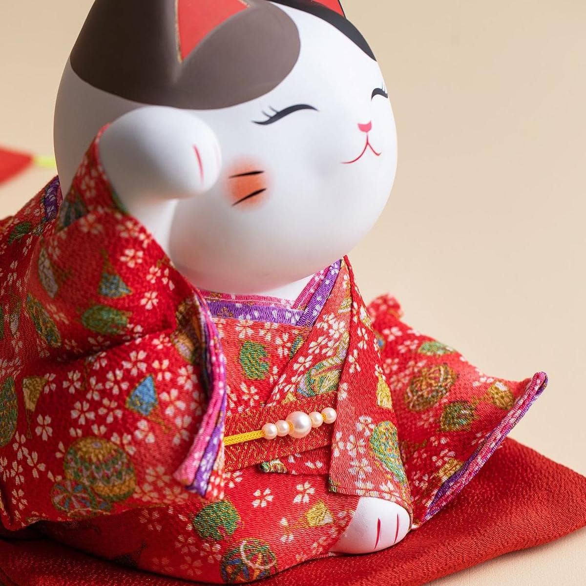 Handcrafted Japanese lucky cat figurine in a red kimono