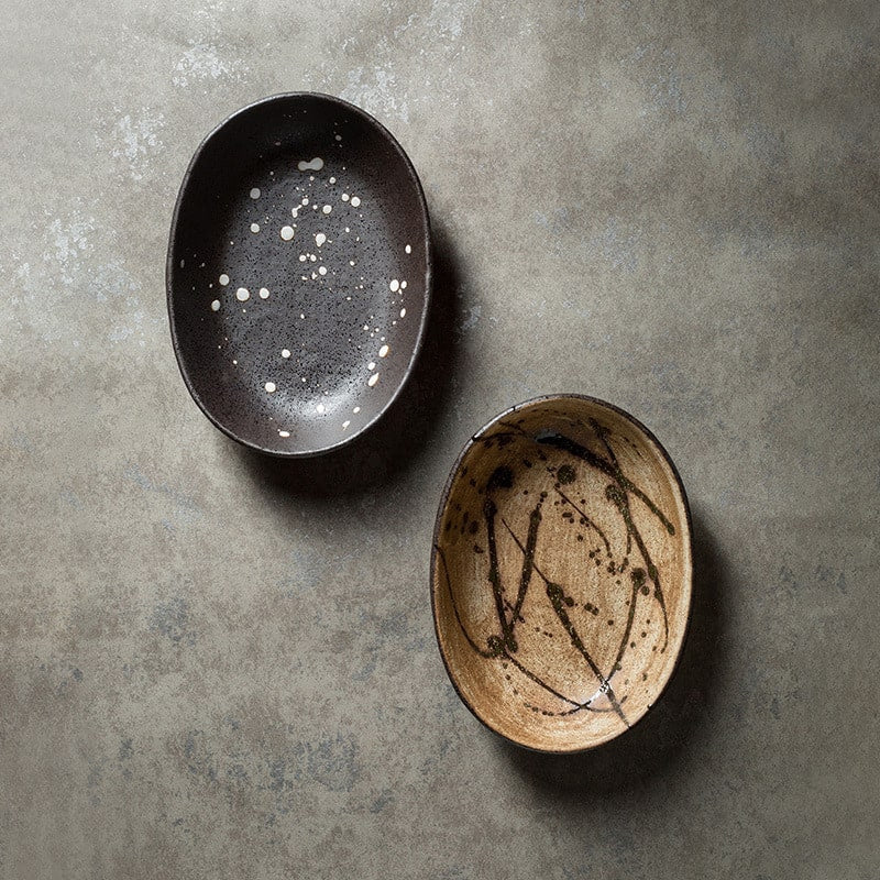 Rustic ceramic plate with splattered black design on table