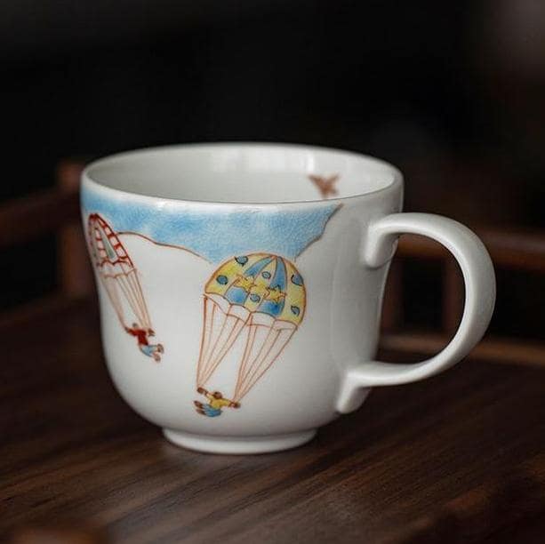 Ceramic mugs with floral and balloon designs on a wooden shelf