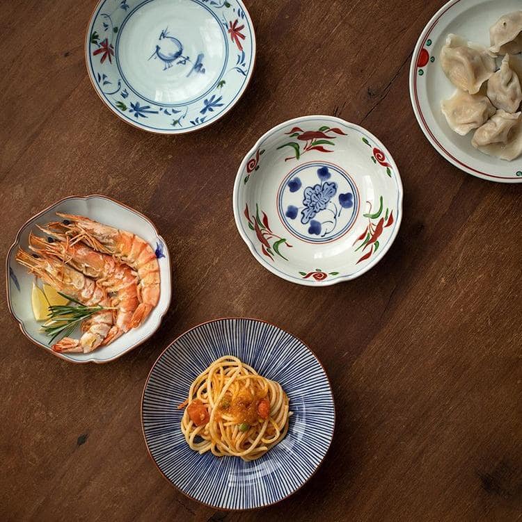 Hand-painted Japanese ceramic plates set displayed on a wooden table