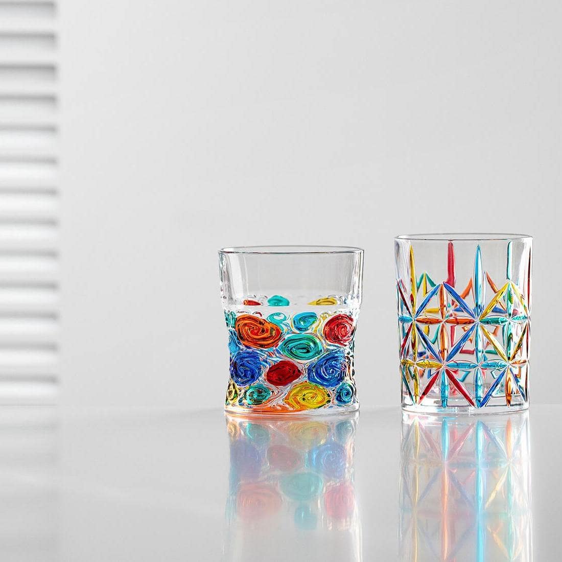 Italian mosaic glassware with colorful reflections on a white background